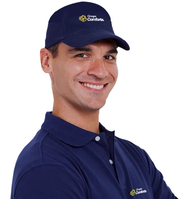 Employé souriant du Groupe Conforta, portant un uniforme bleu avec le logo de l'entreprise et une casquette assortie.